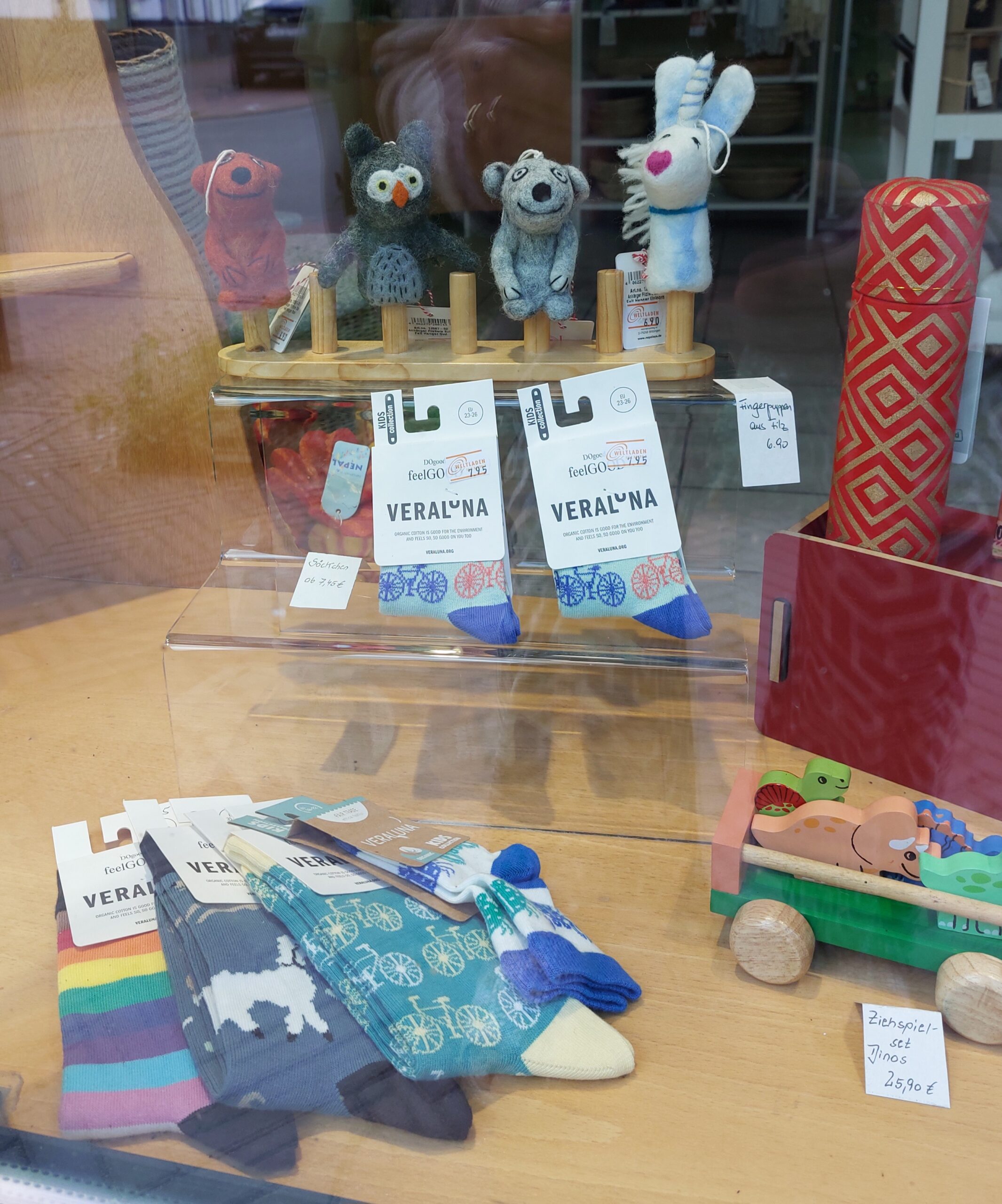 Schaufenster des Eine-Welt-Ladens. Fingerpuppen. Strümpfe für Kinder.