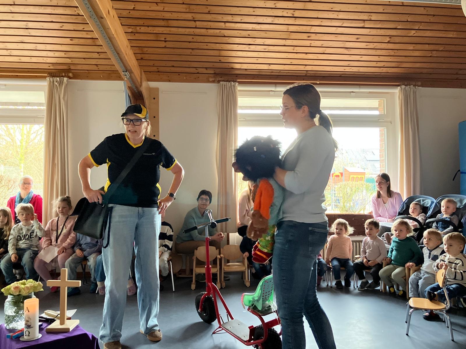 Eine als Postbotin verkleidete Erzieherin der Kita und eine weitere Erzieherin mit einer Handpuppe.